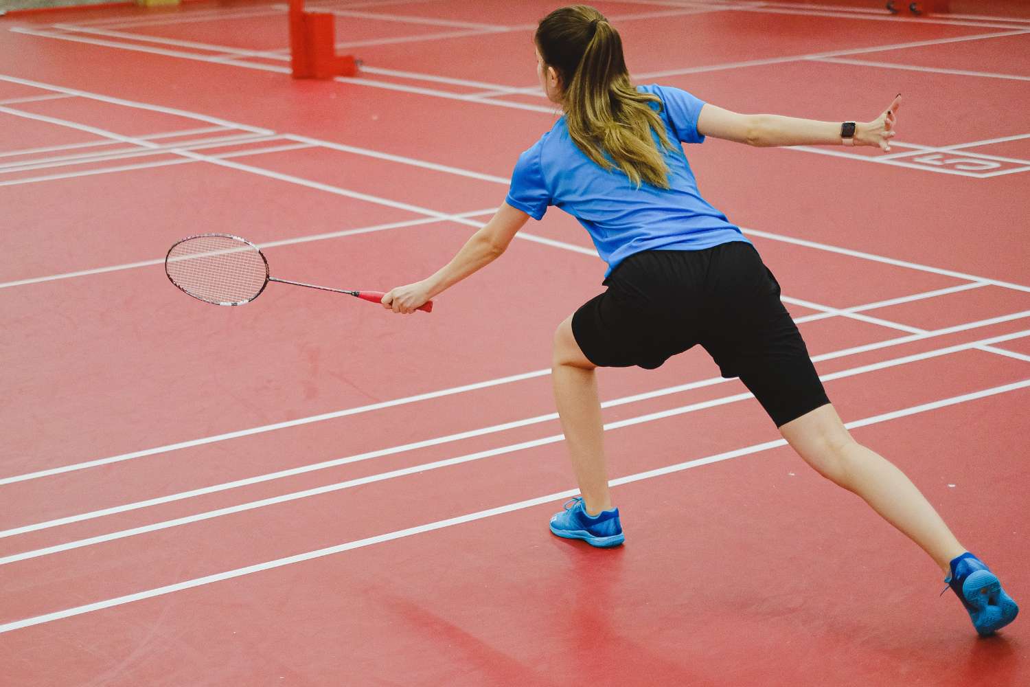 a female badminton player reaches for the shuttlecock